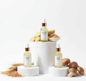 Three serum bottles comparing glycolic acid, azelaic acid, and kojic acid with their natural source ingredients
